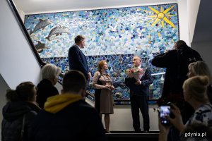 Tłum ludzi pod mozaiką w przychodni.