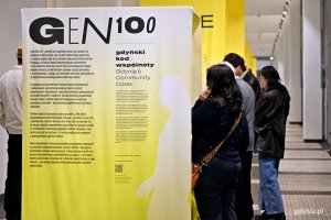 Uczestnicy wernisażu wystawy &bdquo;Gen 100 &ndash; gdyński kod wsp&oacute;lnoty&rdquo; oglądający ekspozycję w Muzeum Emigracji 