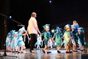 grupa dzieci na scenie przebranych za rybki, tańczących w kole