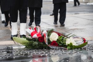 Wiązanka składająca się z białych i czerwonych róż leżąca na pomniku Polski Morskiej // fot. Kamil Złoch
