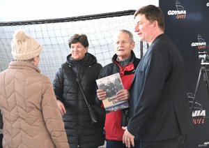 Grupa osób, jeden mężczyzna trzyma książkę o hisotrii dzielnicy