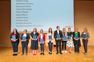 Osoby na scenie pozujace po wręczeniu nominacji