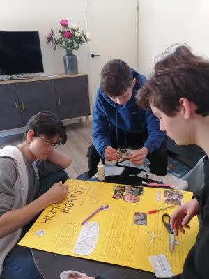 Licealiści tworzący plakat o prawach człowieka