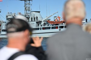 Ludzie fotografują przepływający okręt