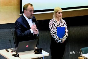 Mężczyzna i kobieta stojący za pulpitem z laptopem