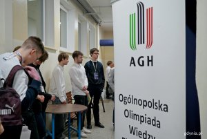 Uczestnicy olimpiady i przedstawiciele organizatora przed jedną z sal egzaminacyjnych 