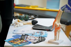 Ulotki, modele staw&oacute;w i przyrządy do ćwiczeń na stoisku fizjoterapeuty