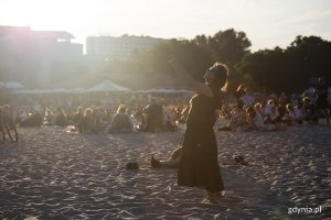 Kobieta tańczy na plaży.