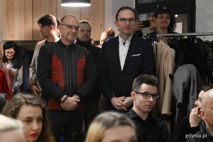 Dwaj mężczyźni stoją w tłumie młodych ludzi podczas otwarcia centrum kultury.