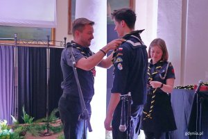 phm. Krystian Domański nakłada jednemu z harcerzy chustę Hufca ZHP Gdynia