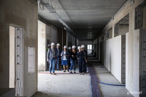 Grupa osób na korytarzu jednej z kondygnacji budynku 