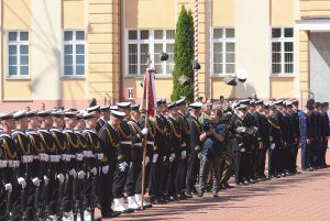 Uroczysta promocja oficerska w Akademii Marynarki Wojennej w Gdyni. Żołnierze stoją ustawieni w rzędzie. Po prawej stronie absolwenci rzucają do góry czapki // fot. Krzysztof Miłosz