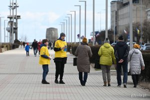 Dwaj wolontariusze w żółtych koszulkach i spacerujący al. Jana Pawła II przechodnie // fot. Michał Puszczewicz