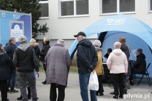 uczestnicy akcji w kolejce do rejestracji w niebieskim namiocie na badania