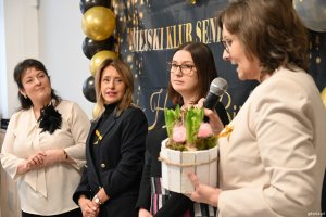 Trzy panie składają seniorom życzenia od zaprzyjaźnionego przedszkola