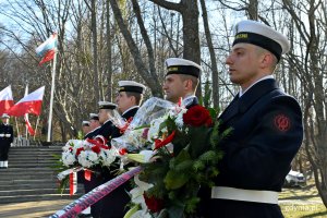 Sześciu marynarzy stoi w rzędzie podczas uroczystości z okazji 77. rocznicy zakończenia walk o Gdynię. W rękach trzymają wieńce i wiązanki kwiatów // fot. Magdalena Czernek