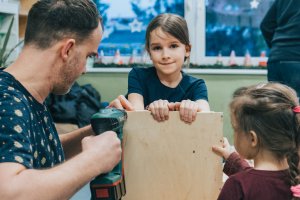 Tata z dziećmi buduje karmnik w Zespole Szkolno-Przedszkolnym nr 1 w Gdyni
