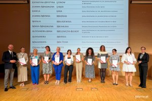 Osoby na scenie pozujące do zdjęcia po wręczeniu nominacji