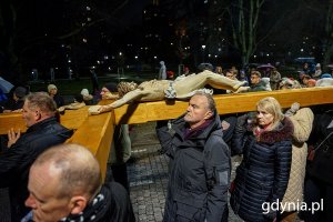 Ludzie idą ulicami miasta w czasie drogi krzyżowej.