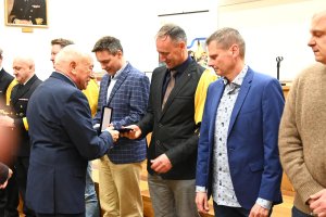 Grupa mężczyn z ż&oacute;łtymi chustami na scenie