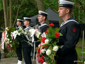 Marynarze z wieńcami w rękach ustawieni w szeregu podczas uroczystości z okazji 84. rocznicy agresji niemieckiej na Polskę 