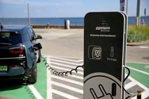 Jedna ze stacji ładowania samochodów elektrycznych stoi na skwerze Arki Gdynia. Na pierwszym planie stacja ładowania. Jeden z kabli podpięty jest do samochodu // fot. Przemysław Kozłowski