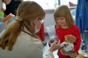Prezydent Aleksandra Kosiorek wręcza pluszowego misia i butelkę jednej z małych pacjentek Oddziału Pediatrycznego Szpitala św. Wincentego a Paulo w Gdyni 