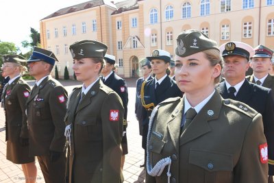 Akademia Marynarki Wojennej, plac, promocja oficerska, w szeregu stoją kobiety w mundurach, w tle wojsko i budynek uczelni