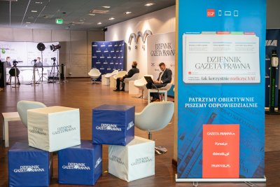 Hol w centrum konferencyjnym PPNT Gdynia, widoczne ścianki z logotypami i rozmowa w studio