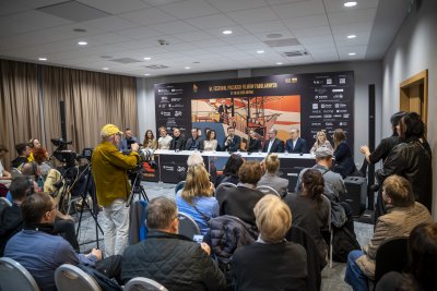 Sala konferencyjna, ścianka FPFF w Gdyni, grupa osób siedząca za stołem
