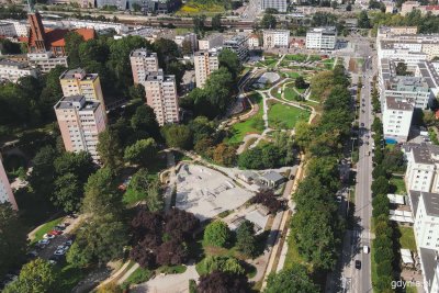 Park Centralny w Gdyni, zdjęcie z drona, widoczny drugi i trzeci etap, ściezki, drzewa, trawniki, skatepark, aleja Piłsudskiego obok, budynki, część Gdyni, słoneczny dzień