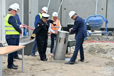Paweł Lulewicz - prezes zarządu PGZ Stoczni Wojennej oraz kmdr Piotr Skóra - szef Szefostwa Techniki Morskiej w Agencji Uzbrojenia umieszczają kapsułę czasu na placu budowy hal stoczniowych // fot. Magdalena Czernek