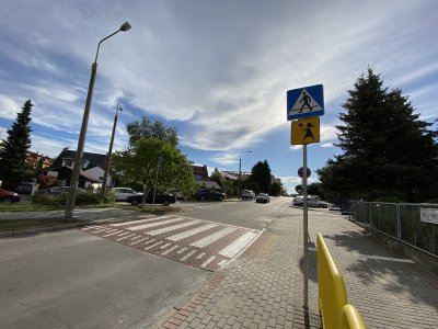 Żółte barierki, znak pionowy informujący o przejściu dla pieszych i znak 'Agatka' oraz wyniesione przejście dla pieszych w okolicy ZWE nr 1 przy ul. Wiczlińskiej na ZDiZ