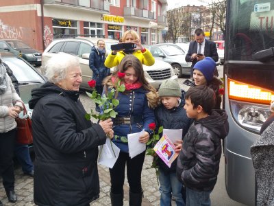 Na zdj. Sylwia Karłowska w towarzystwie opiekunów i dzieci przybyłych z Litwy. Stoją przy autokarze. Pani Sylwia trzyma w ręku róże i laurki od podopiecznych. Mat. fundacji Serce dzieciom.