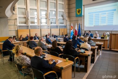 Sala obrad Rady Miasta Gdyni. Radni siedzą przy stołach, na ekranie wyświetla się głosowanie