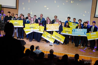 Scena PPNT Gdynia, grupa nastolatków pozuje do zdjęcia, trzymają żółte plansze z nazwami nagród