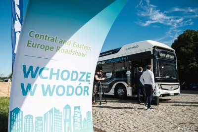 Plac przed PPNT Gdynia, autobus wodorowy na placu, przed nim baner z napisem 
