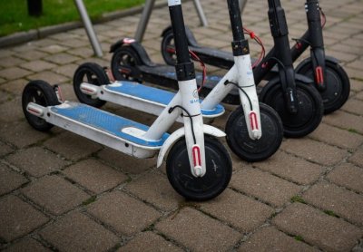 Kilka hulajnóg zaparkowanych na kostce brukowej, zbliżenie