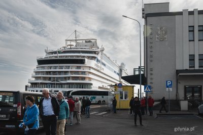 Nabrzeże Francuskie, budynek Muzeum Emigracji, taksówki, przy nabrzeżu statek AIDAmar, widać ludzi chodzących po parkingu