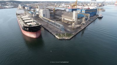 Zdjęcie lotnicze basenu Portu Gdynia z fragmentem nabrzeża. Przy nabrzeżu statek handlowy