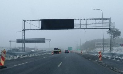Budowana Trasa Kaszubska. Wyłączona tablica drogowa, asfaltowa nawierzchnia, pojazdy budowlane, zima.