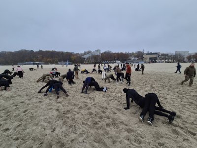 Uczestnicy treningu z Formozą na plaży Śródmieście ćwiczą pompki