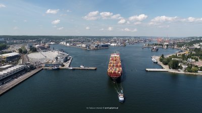 Zdjęcie lotnicze z drona. Basen portu Gdynia, widoczny statek kontenerowy holowany przez wejście do portu