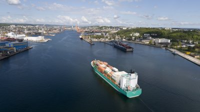 Statek kontenerowy wchodzący do portu w Gdyni. Widoczne nabrzeża i terminal kontenerowy