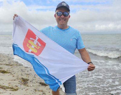 Piotr Biankowski z flagą Gdyni po przepłynięciu Cieśniny Beltquerung (fot. mat. prasowe)