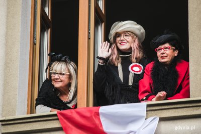 Na zdjęciu trzy kobiety trzymają biało-czerwoną flagę//fot. Karol Stańczak