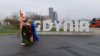 Trzej Królowie na molo Południowym na tle napisu: Gdynia. Z tyłu widać Sea Towers. Fot. ze strony FB: Orszak Trzech Króli Gdynia.
