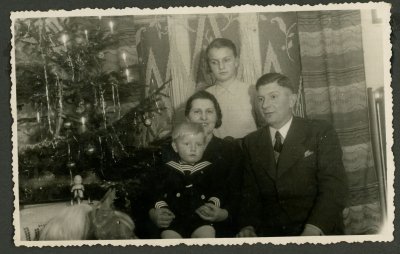 Niezwykłe świąteczne chwile, zaklęte w starych zdjęciach, dziedzictwo naszego miasta. Na fotografii rodzina pozująca do pamiątkowego zdjęcia pod świąteczną choinką. Ze zbiorów Muzeum Miasta Gdyni.