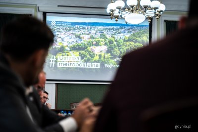 Sala konferencyjna, na ekranie widoczne zdjęcie Wejherowa i napis 