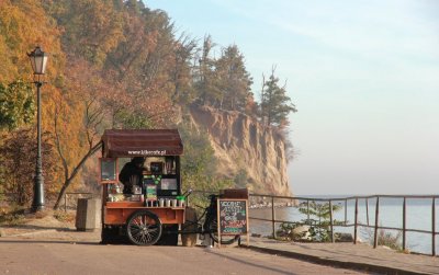 Widoczny Klif Orłowski i fragment chodnika, na którym stoi mobilna kawiarnia. W tle morze.